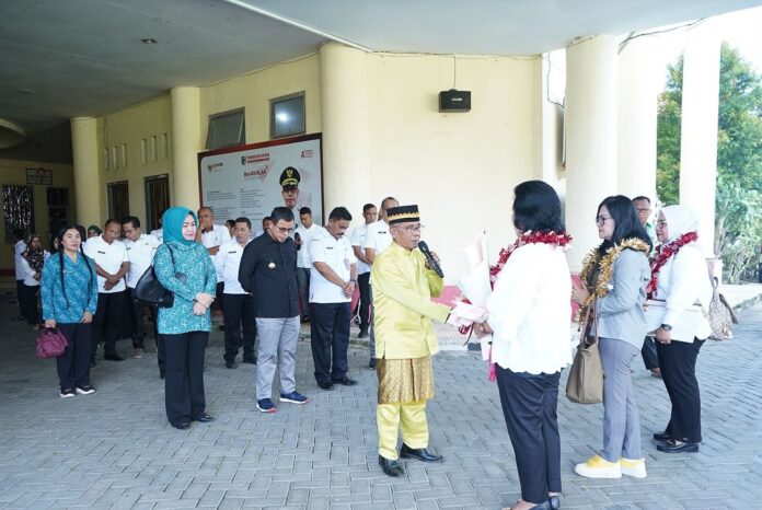 Foto istimewa Pj Bupati Sirajudin Lasena menerima secara adat kunjungan tim Penilaian Kinerja Penurunan Stunting provinsi Sulut dipimpin oleh Jenny Karouw