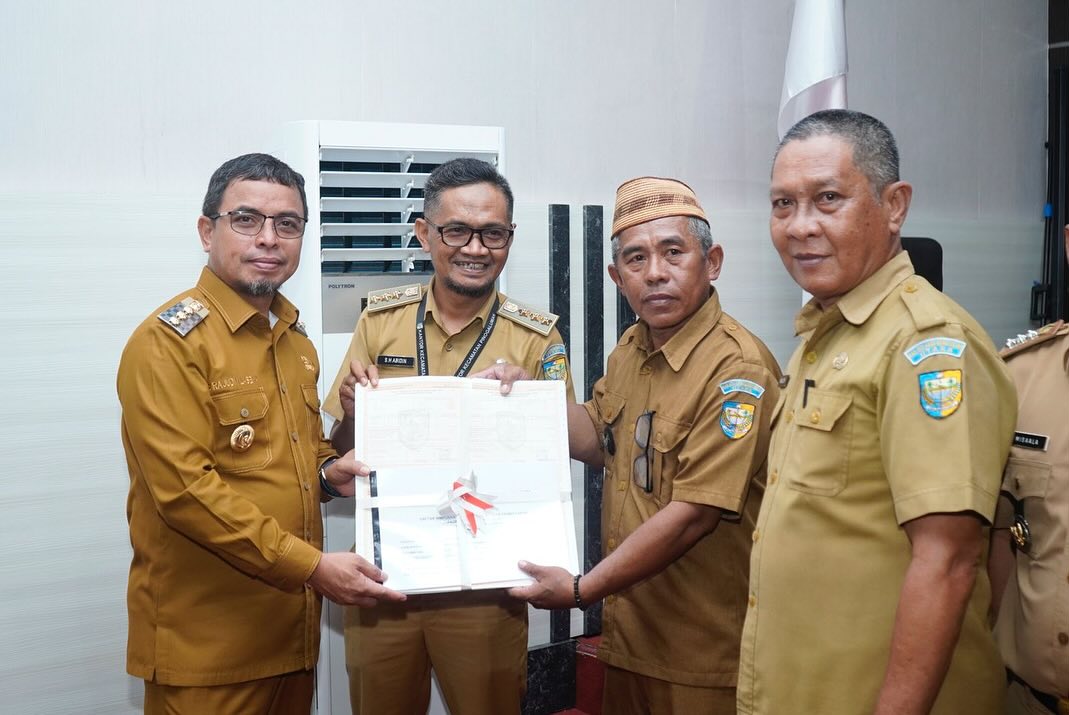 Foto istimewa penyerahan SPPT dan PBB P2 oleh Pj Bupati Bolmut Sirajudin Lasena yang didampingi oleh Kepala BPKPD kepada Camat pinogaluman dan sangadi