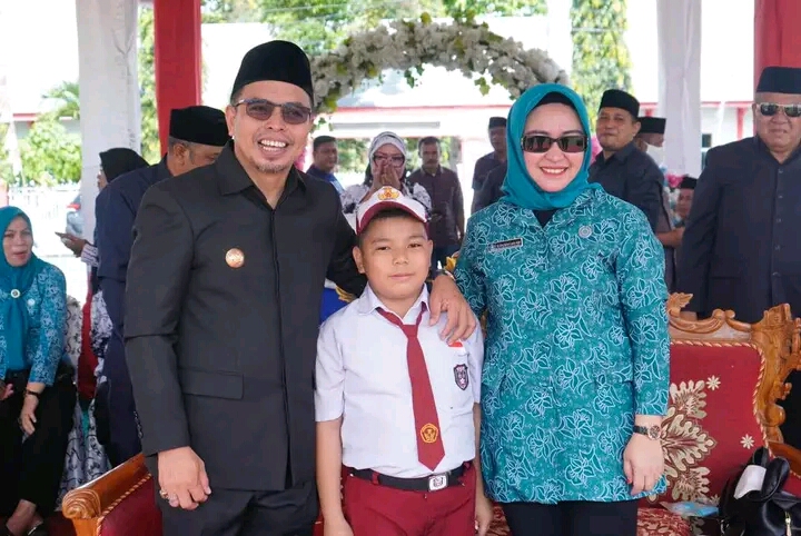 Foto Bupati Sirajudin Lasena bersama Ketua TP PKK Bolmut Ny. Ening Sutrisni Lasena Adam dan seorang siswa.