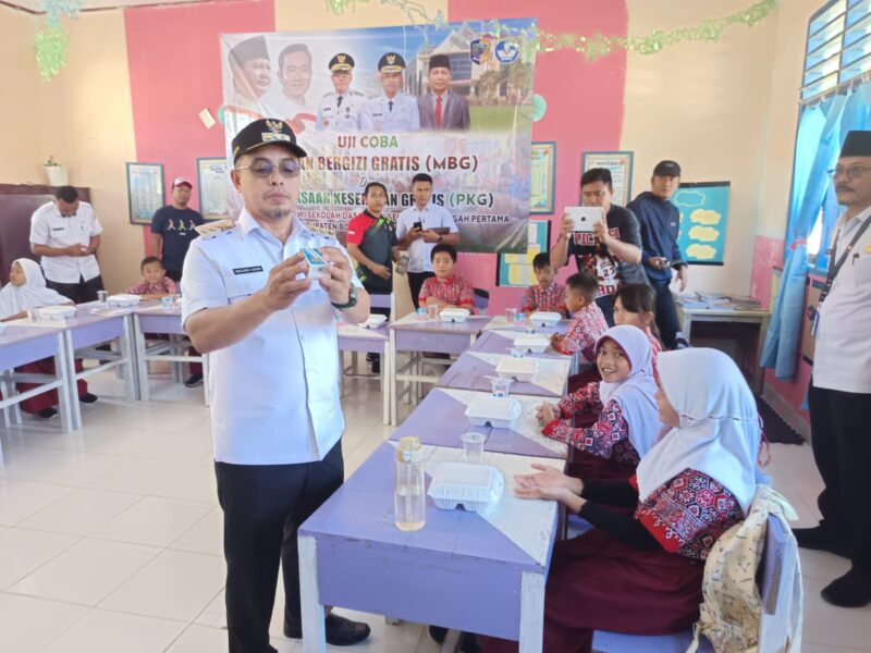 Bupati Bolmut Dr. Sirajudin Lasena saat memeriksa daftar kadaluarsa minuman yang akan dikonsumsi siswa dan siswi penerima program MBG