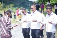 Mandi safar oleh Asisten Bidang Pemerintahan dan Kesra, Rahmat R. Pontoh (tengah), Camat Pinogaluman, Sarwan Abidin (kanan) dan anggota DPRD Boltara, Mardan Umar (kiri) 