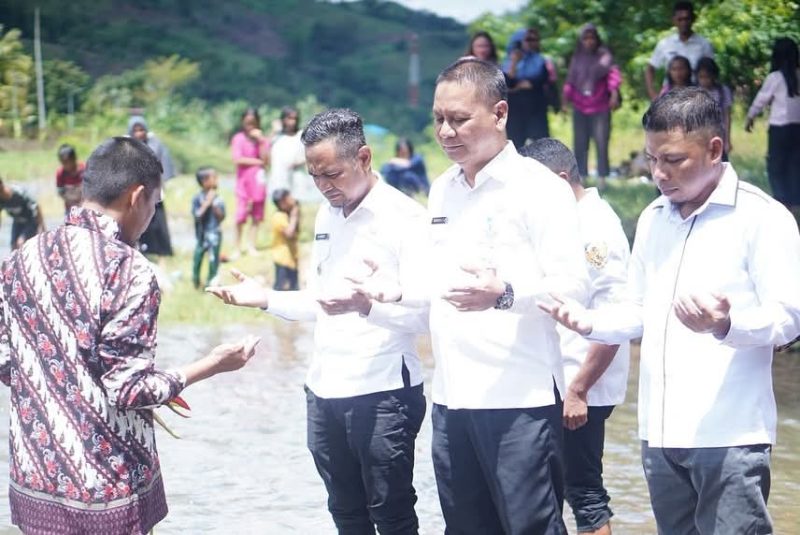 Mandi safar oleh Asisten Bidang Pemerintahan dan Kesra, Rahmat R. Pontoh (tengah), Camat Pinogaluman, Sarwan Abidin (kanan) dan anggota DPRD Boltara, Mardan Umar (kiri) 