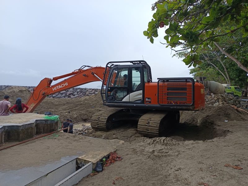 (Foto istimewa) Salah satu unit excavator sedang melaksanakan proyek pengerjaan pembangunan pantai batu Pinagut, oleh kontraktor PT Indahjaya Karya Abadi, Kamis (21/08/2025). 