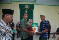 Wakil Bupati Boltara, Moh. Aditya Pontoh menyerahkan secara simbolis benih jagung hibrida pada salah satu kelompok tani di kecamatan kaidipang