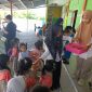Bunda TK PAUD Budi Mania Boroko, saat membagikan makanan bergizi jenis buah-buahan pada anak didik usia dini