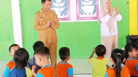 Sekda Boltara, dr. Jusnan C. Mokoginta saat mengunjungi dan turut bermain bersama anak-anak di PAUD TK KB Budi Mania Boroko. 