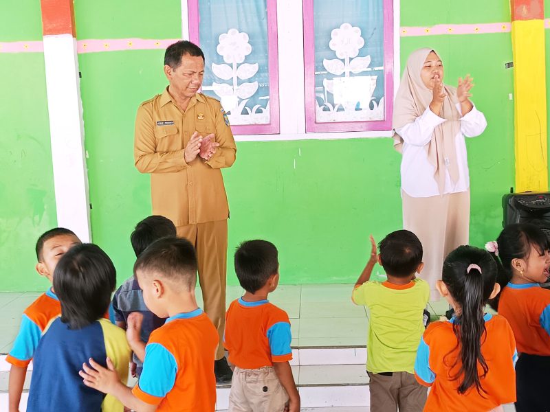 Sekda Boltara, dr. Jusnan C. Mokoginta saat mengunjungi dan turut bermain bersama anak-anak di PAUD TK KB Budi Mania Boroko. 