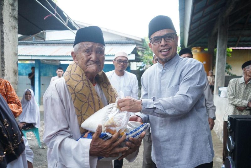 Bupati Boltara, Dr. Sirajudin Lasena menyerahkan bantuan sembako pada masyarakat di momentum Safari Ramadhan di kecamatan Sangkub