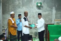 Bupati Boltara, Dr. Sirajudin Lasena menyerahkan bantuan Al-Qur'an kepada imam masjid Al-Amin desa Padang Barat, Kecamatan Bintauna pada rangkaian Safari Ramadhan