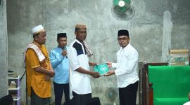 Bupati Boltara, Dr. Sirajudin Lasena menyerahkan bantuan Al-Qur'an kepada imam masjid Al-Amin desa Padang Barat, Kecamatan Bintauna pada rangkaian Safari Ramadhan