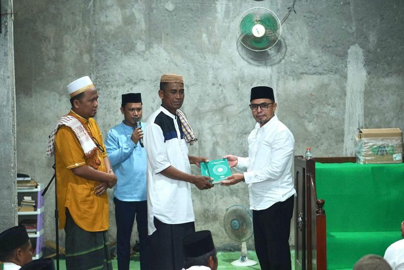 Bupati Boltara, Dr. Sirajudin Lasena menyerahkan bantuan Al-Qur'an kepada imam masjid Al-Amin desa Padang Barat, Kecamatan Bintauna pada rangkaian Safari Ramadhan