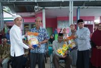 Bupati dan Wakil Bupati Boltara menyerahkan bantuan sembako kepada masyarakat, yang merupakan rangkaian Safari Ramadhan 1447 Hijriah di Kecamatan Pinogaluman