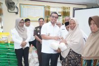 Bupati Boltara, Dr. Sirajudin Lasena menyerahkan sejumlah bahan pokok di rangkaian kegiatan pasar murah di desa Inomunga kepada masyarakat