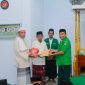 Ketua GP Ansor Boltara, Agung Aditya Saenong menyerahkan Al-Quran di Momen safari ramadhan dan diterima langsung oleh Imam Masjid Al-Ikhsan Desa Binjeita
