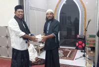 Anggota Tim VII Masruru Salele Menyerahkan Wakaf Al-Qur'an kepada Sekretaris Mushollah Cokro Aminoto Petta Balane