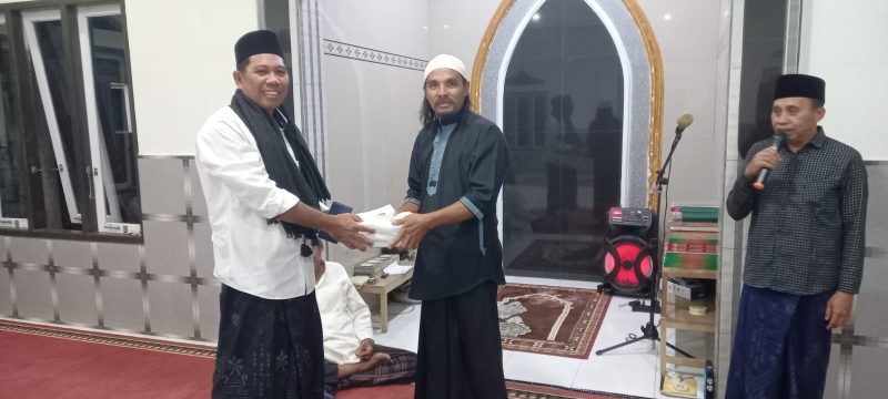 Anggota Tim VII Masruru Salele Menyerahkan Wakaf Al-Qur'an kepada Sekretaris Mushollah Cokro Aminoto Petta Balane