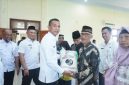 Wakil Bupati Boltara, Moh. Aditya Pontoh menyerahkan bantuan beras cadangan pangan kepada masyarakat penerima manfaat