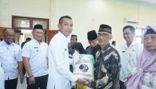 Wakil Bupati Boltara, Moh. Aditya Pontoh menyerahkan bantuan beras cadangan pangan kepada masyarakat penerima manfaat