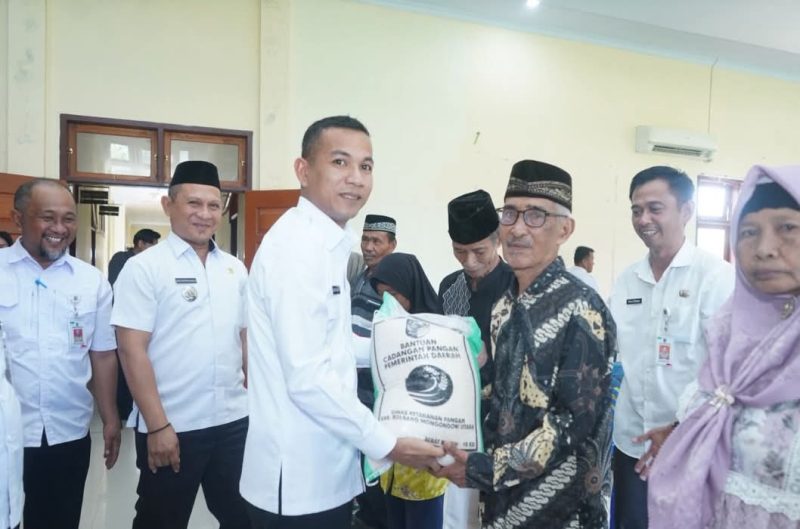 Wakil Bupati Boltara, Moh. Aditya Pontoh menyerahkan bantuan beras cadangan pangan kepada masyarakat penerima manfaat