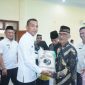 Wakil Bupati Boltara, Moh. Aditya Pontoh menyerahkan bantuan beras cadangan pangan kepada masyarakat penerima manfaat