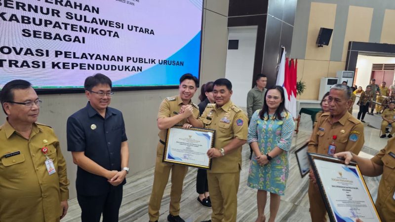 Gubernur Sulawesi Utara Mayjen TNI (Purn.) Yulius Selvanus menyerahkan penghargaan kepada Bupati Kabupaten Kepulauan Sangihe Michael Thungari