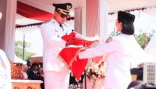 Bupati Boltara Sirajudin Lasena menyerahkan sang saka Merah Putih pada Nur Keila Djibran dari SMA Negeri 1 Pinogaluman sebagai pembawa baki