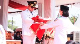 Bupati Boltara Sirajudin Lasena menyerahkan sang saka Merah Putih pada Nur Keila Djibran dari SMA Negeri 1 Pinogaluman sebagai pembawa baki