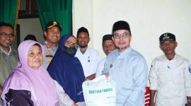 Bupati Boltara Sirajudin Lasena menyerahkan bantuan beras kepada KPM