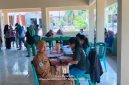 Penjabat Kapitalaung Kampung Bahu Farmyati Maniku bersama dengan Petugas Kesehatan Puskesmas Kalasuge