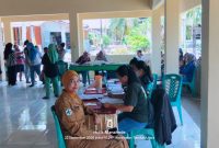 Penjabat Kapitalaung Kampung Bahu Farmyati Maniku bersama dengan Petugas Kesehatan Puskesmas Kalasuge