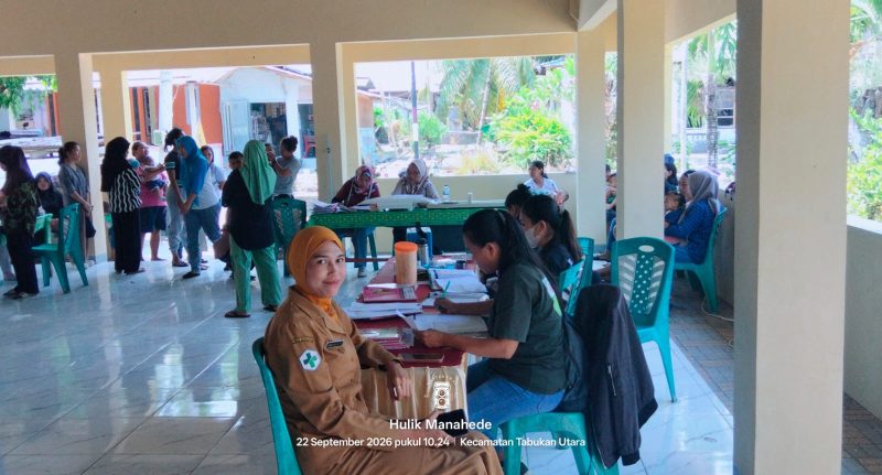 Penjabat Kapitalaung Kampung Bahu Farmyati Maniku bersama dengan Petugas Kesehatan Puskesmas Kalasuge