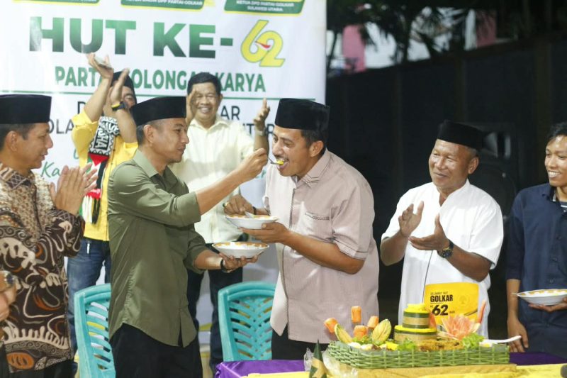 Ketua DPD II Partai Golkar Boltara Saiful Ambarak menerima suapan tumpeng sebagai bentuk perayaan HUT Golkar ke-62 oleh Plt Bupati Boltara Mohammad Aditya Pontoh
